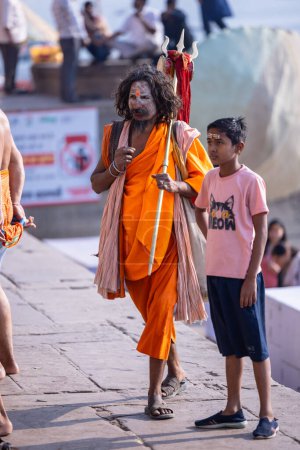 Photo for Varanasi, Uttar Pradesh, India - March 05, 2023: Portrait of holy sadhu baba in traditional dress walking on the ghats near ganges in varanasi - Royalty Free Image