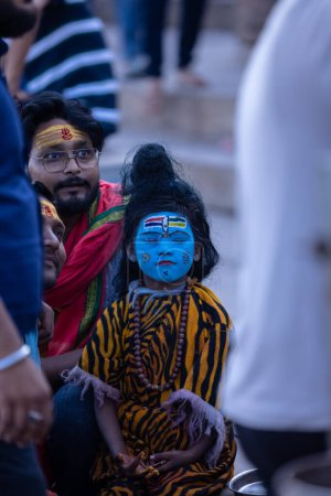 Photo for Varanasi, Uttar Pradesh, India - March 05 2023: Masan Holi, Portrait of a young boy dressed like lord shiva with painted face at dashashwamedh ghat in varanasi during holi festival. - Royalty Free Image