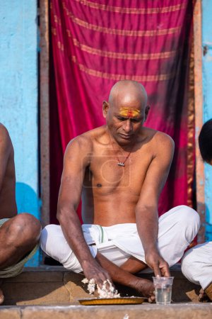 Foto de Varanasi, Uttar Pradesh, India - 05 de marzo de 2023: Retrato de hombres brahmin no identificados del sur de la India realizando rituales shraadh en el ghat kedar cerca de las bandas fluviales en varanasi - Imagen libre de derechos