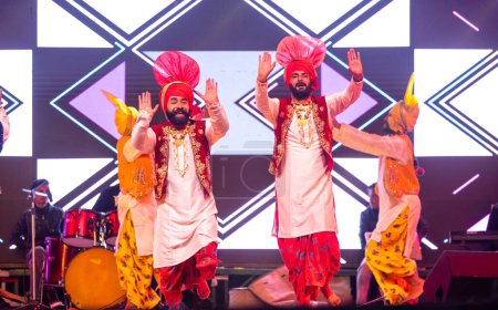 Téléchargez les photos : Bikaner, Rajasthan, Inde - 14 janvier 2023 : Groupe de jeunes artistes punjabis du Pendjab interprétant la célèbre danse bhangra en couleur traditionnelle au festival de chameaux bikaner - en image libre de droit