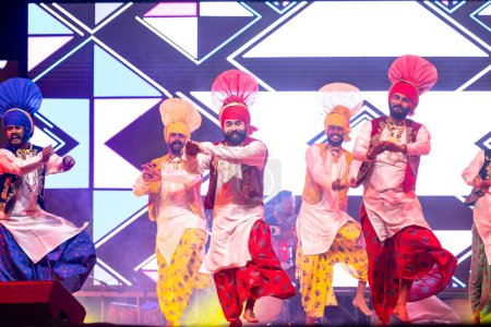 Foto de Bikaner, Rajastán, India - 14 de enero de 2023: Grupo de jóvenes artistas masculinos punjabi de Punjab que realizan famosos bailes de bhangra en colorido tradicional en el festival de camellos bikaner - Imagen libre de derechos