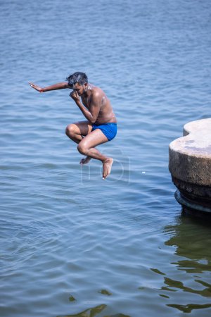 Photo for Varanasi, Uttar Pradesh, India - March 05 2023: Portrait of young boy jumping into river ganges for fun - Royalty Free Image