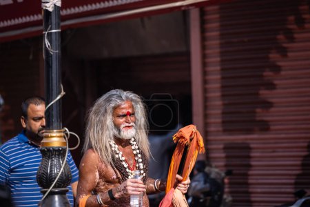 Photo for Varanasi, Uttar Pradesh, India - March 05, 2023: Portrait of old holy sadhu baba in traditional dress walking on ghats near ganges in varanasi. Kashi is the oldest and holy city - Royalty Free Image