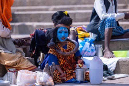 Téléchargez les photos : Varanasi, Uttar Pradesh, Inde - 05 mars 2023 : Masan Holi, Portrait d'un jeune garçon habillé comme shiva de seigneur avec le visage peint au ghat de dashashwamedh à varanasi pendant le festival de holi - en image libre de droit