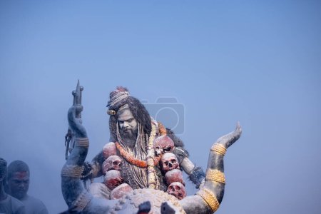Photo for Masan Holi, Portrait of an male artist act as lord shiv with dry ash on face and body also in air while celebrating the holi festival as tradition at Harishchandra ghat in varanasi, India. - Royalty Free Image