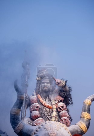 Masan Holi, Porträt eines männlichen Künstlers als Lord Shiv mit trockener Asche auf Gesicht und Körper auch in der Luft, während er das Holi-Fest als Tradition im Harishchandra-Ghatt in Varanasi, Indien feiert.
