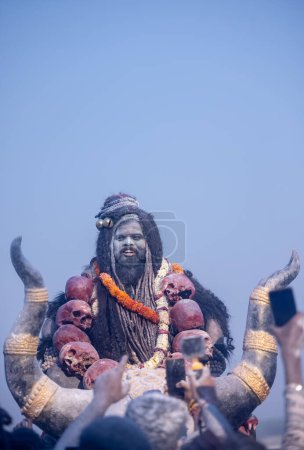 Photo for Masan Holi, Portrait of an male artist act as lord shiv with dry ash on face and body also in air while celebrating the holi festival as tradition at Harishchandra ghat in varanasi, India. - Royalty Free Image