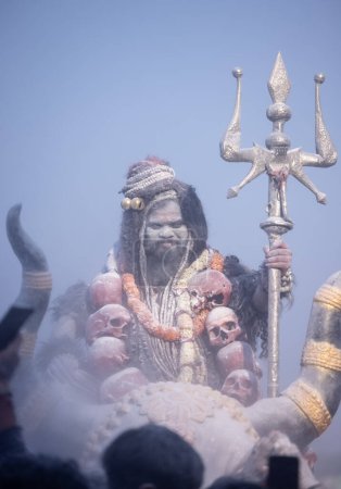 Masan Holi, Retrato de un artista masculino actuar como señor shiv con ceniza seca en la cara y el cuerpo también en el aire mientras se celebra el festival de holi como tradición en Harishchandra ghat en varanasi, India.