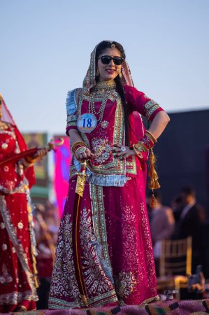 Foto de Bikaner, Rajastán, India - 14 de enero de 2023: Retrato de una joven india hermosa en vestido de rajasthani lehenga choli étnico que participa en el desfile de moda Miss Marwar durante el festival de camellos de ciclista - Imagen libre de derechos