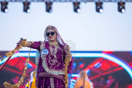 Photo for Bikaner, Rajasthan, India - January 14 2023: Portrait of young beautiful indian woman  in ethnic rajasthani lehenga choli dress participating in miss marwar fashion show during bikaner camel festival - Royalty Free Image