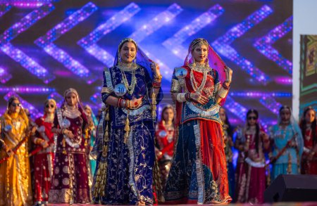 Photo for Bikaner, Rajasthan, India - January 14 2023: Portrait of young beautiful indian women  in ethnic rajasthani lehenga choli dress participating in miss marwar fashion show during bikaner camel festival - Royalty Free Image