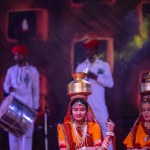 Pushkar, Rajasthan, India - November 05, 2022: An female artists performing rajasthani folk dance Ghoomar in traditional colorful dresses and metal pots with fire in Pushkar fair. Selective focus.