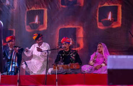 Foto de Pushkar, Rajastán, India - 06 de noviembre de 2022: Retrato de un artista folclórico masculino de Rajastán actuando en el escenario durante la feria de camellos en traje tradicional y turbante colorido - Imagen libre de derechos