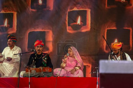 Téléchargez les photos : Pushkar, Rajasthan, Inde - 06 novembre 2022 : Portrait d'un artiste folklorique du rajasthan se produisant sur scène lors de la foire du chameau pushkar en tenue traditionnelle et turban coloré - en image libre de droit