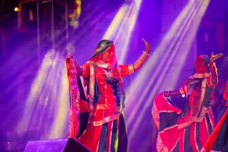 Foto de Pushkar, Rajastán, India - 05 de noviembre de 2022: Retrato de una joven artista hermosa que realiza danza folclórica con velo en la cabeza durante la feria de pushkar en colorido vestido rajastaní étnico. - Imagen libre de derechos