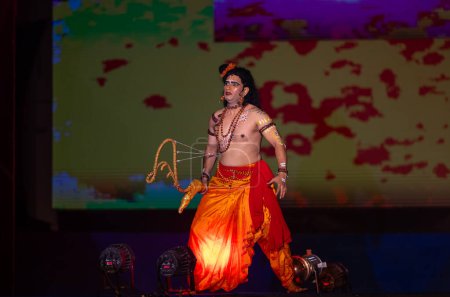 Téléchargez les photos : Ghaziabad, Uttar Pradesh, Inde - 23 octobre 2023 : Artiste masculin jouant le personnage du dieu hindou laxman avec son personnage d'arc flèche de ramayana in ramlila pendant le festival de dussehra. - en image libre de droit