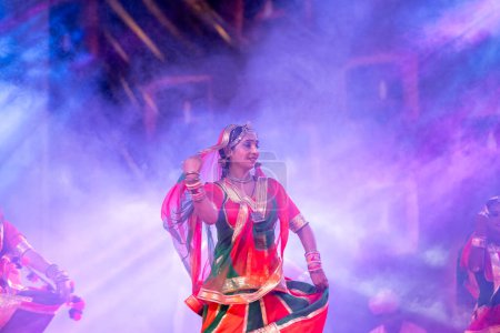 Téléchargez les photos : Pushkar, Rajasthan, Inde - 05 novembre 2022 : Portrait d'une jeune belle artiste féminine exécutant une danse folklorique avec voile sur la tête pendant la foire de pushkar en robe rajasthani ethnique colorée. - en image libre de droit