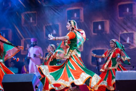 Téléchargez les photos : Pushkar, Rajasthan, Inde - 05 novembre 2022 : Portrait d'une jeune belle artiste féminine exécutant une danse folklorique avec voile sur la tête pendant la foire de pushkar en robe rajasthani ethnique colorée. - en image libre de droit