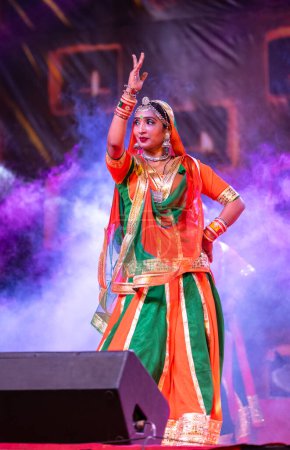 Photo for Pushkar, Rajasthan, India - November 05 2022: Portrait of young beautiful female artist performing folk dance with veil on head during pushkar fair in colorful ethnic rajasthani dress. - Royalty Free Image