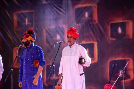 Téléchargez les photos : Pushkar, Rajasthan, Inde - 06 Novembre 2022 : Portrait d'artistes folkloriques masculins du rajasthan se produisant sur scène lors de la foire du chameau pushkar en tenue traditionnelle et turban coloré - en image libre de droit