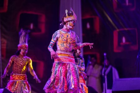 Foto de Pushkar, Rajastán, India - 06 de noviembre de 2022: Artistas masculinos indios realizan danza folclórica rajasthani tribu Sahariya con la cara pintada y pintura colorida en el cuerpo con vestido étnico en la feria. - Imagen libre de derechos