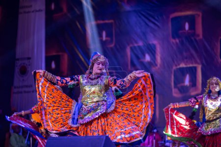 Photo for Pushkar, Rajasthan, India - November 06 2022: Female artist performing rajasthani folk dance on stage at pushkar fair in colorful ethnic rajasthani dress and jewellery. - Royalty Free Image