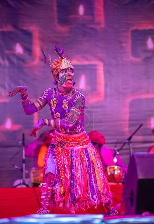 Foto de Pushkar, Rajastán, India - 06 de noviembre de 2022: Artista masculino indio realizando danza folclórica rajasthani tribu Sahariya con la cara pintada y pintura colorida en el cuerpo con vestido étnico en la feria. - Imagen libre de derechos