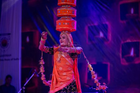 Photo for Pushkar, Rajasthan, India - November 06 2022: Artist performing rajasthani folk dance on stage at pushkar fair in colorful ethnic rajasthani dress and jewellery. - Royalty Free Image