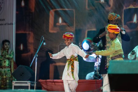 Téléchargez les photos : Pushkar, Rajasthan, Inde - 06 Novembre 2022 : Portrait de deux enfants artiste folklorique du rajasthan se produisant sur scène lors de la foire du chameau pushkar en tenue traditionnelle et turban coloré. - en image libre de droit