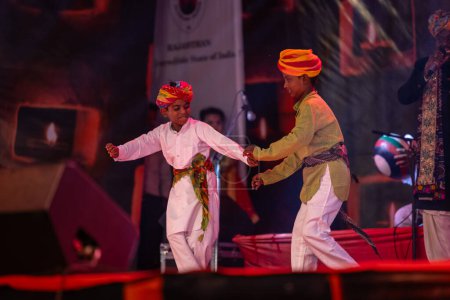 Foto de Pushkar, Rajastán, India - 06 de noviembre de 2022: Retrato de dos niños artistas folclóricos de Rajastán actuando en el escenario durante la feria de camellos de pushkar en traje tradicional y turbante colorido. - Imagen libre de derechos