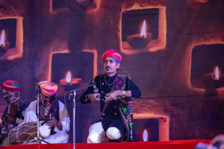 Téléchargez les photos : Pushkar, Rajasthan, Inde - 06 Novembre 2022 : Portrait d'artistes folkloriques masculins du rajasthan se produisant sur scène lors de la foire du chameau pushkar en tenue traditionnelle et turban coloré - en image libre de droit