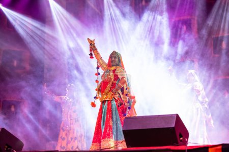 Téléchargez les photos : Pushkar, Rajasthan, Inde - 06 Novembre 2022 : Belles artistes féminines exécutant la danse folklorique rajasthani sur scène à la foire pushkar dans des robes et des bijoux ethniques rajasthani colorés. - en image libre de droit