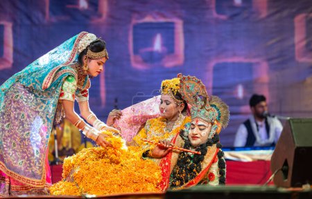 Téléchargez les photos : Pushkar, Rajasthan, Inde - 06 Novembre 2022 : Portrait d'un jeune artiste masculin exécutant des fleurs holi en tant que seigneur krishna lors de la foire de pushkar en vêtements ethniques colorés. - en image libre de droit