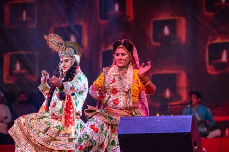 Foto de Pushkar, Rajastán, India - 06 de noviembre de 2022: Artistas interpretando flores holi como lord krishna durante la feria de pushkar con ropa étnica colorida. - Imagen libre de derechos