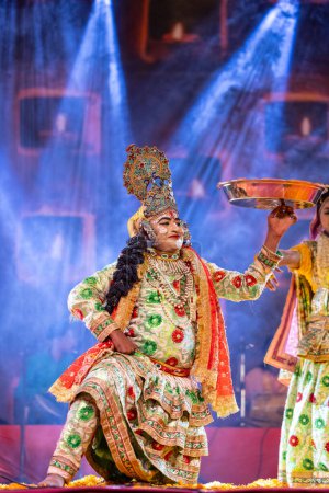 Téléchargez les photos : Pushkar, Rajasthan, Inde - 06 Novembre 2022 : Artiste masculin exécutant holi fleurs comme seigneur krishna lors de la foire pushkar dans des vêtements ethniques colorés. - en image libre de droit