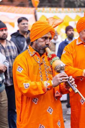 Photo for Ghaziabad, Uttar Pradesh, India - January 28 2024: Portrait of male folk artist of snake charmer community performing with musical instrument in traditional clothes during iskon rath yatra. - Royalty Free Image