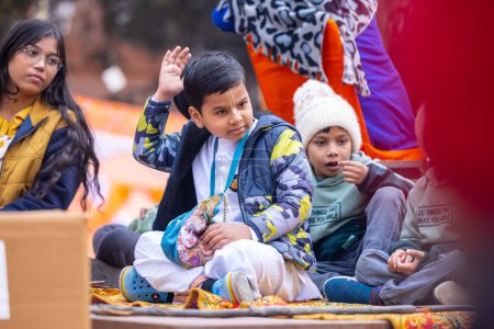 Photo for Ghaziabad, Uttar Pradesh, India - January 28 2024: Portrait of kids participating in lord jagannath rathyatra in colourful clothes and holding flags. - Royalty Free Image