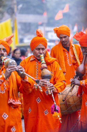 Photo for Ghaziabad, Uttar Pradesh, India - January 28 2024:Male folk artists of snake charmer community performing with musical instrument in traditional clothes during iskon rath yatra. - Royalty Free Image