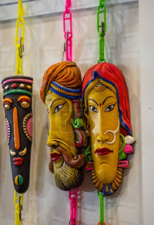 Foto de Handmade colorful tribal look face mask souvenir hanging on plain background. Selective focus on object. - Imagen libre de derechos