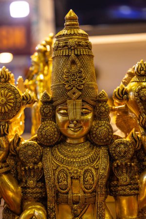 Brass metal art, Handmade Indian Lord Tirupati Balaji sculpture souvenir made with brass with plain background. Selective focus.