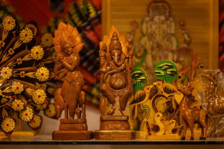 Wooden art, Handmade idol of hindu god ganesh on display at fair.