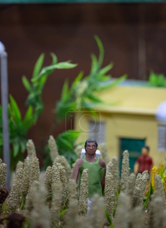 Téléchargez les photos : Idole faite à la main de fermier indien tout en travaillant dans un champ agricole fait d'argile. Concentration sélective. - en image libre de droit