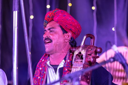 Téléchargez les photos : Bikaner, Rajasthan, Inde - 13 janvier 2023 : Festival du chameau, Portrait de l'artiste masculin rajasthani se produisant sur scène pendant le festival du chameau bikaner en robe rajasthani traditionnelle et turban coloré. - en image libre de droit