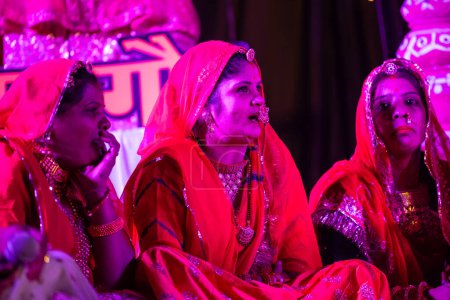 Téléchargez les photos : Bikaner, Rajasthan, Inde - 13 janvier 2023 : Groupe de belles femmes de bikaner vêtues de vêtements rajashani colorés traditionnels et jouant du gangaure culturel pooja sur scène pendant le festival du chameau. - en image libre de droit