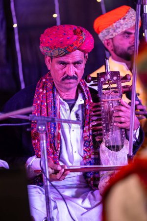 Téléchargez les photos : Bikaner, Rajasthan, Inde - 13 janvier 2023 : Festival du chameau, Portrait de l'artiste masculin rajasthani se produisant sur scène pendant le festival du chameau bikaner en robe rajasthani traditionnelle et turban coloré. - en image libre de droit
