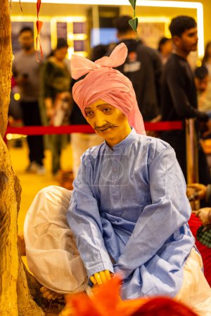 Téléchargez les photos : New Delhi, Inde - 18 novembre 2023 : Idole faite à la main sur des gens de Haryana en tenue ethnique manifestée à Delhi lors du salon. - en image libre de droit