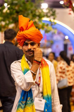 Téléchargez les photos : New Delhi, Inde - 18 novembre 2023 : Portrait d'un artiste folklorique indien regardant la caméra en tenue traditionnelle pour participer au salon. - en image libre de droit