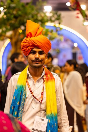 Téléchargez les photos : New Delhi, Inde - 18 novembre 2023 : Portrait d'un artiste folklorique indien regardant la caméra en tenue traditionnelle pour participer au salon. - en image libre de droit