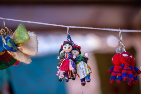 Foto de Faridabad, Haryana, India - 17 de febrero de 2024: Muñecas indias coloridas hechas a mano y títeres y productos de artesanía que cuelgan en la tienda en la feria. Productos de kazakhstan. - Imagen libre de derechos