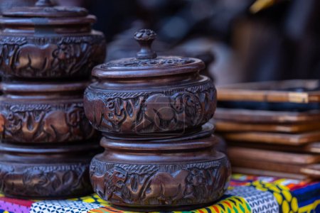 Photo for Wooden bowls with animal carvings done my artist on display for sale. Selective focus. - Royalty Free Image
